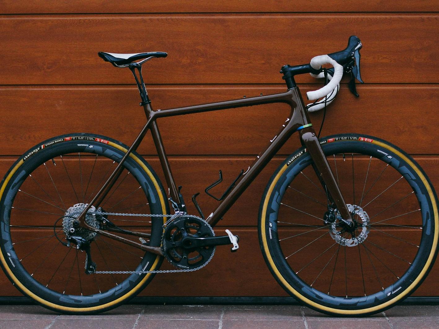 black road bike against wooden wall